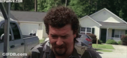 Man With Curly Hair And Beard Standing In Front Of House With Truck GIF