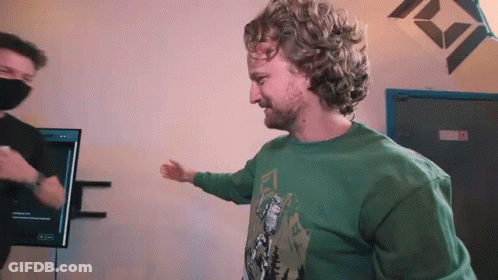 Man With Curly Hair And Beard Wearing Green Shirt And Mask GIF