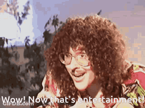 Man With Curly Hair And Glasses Says Wow And Now That's Entertainment GIF