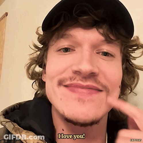 Man With Curly Hair And Hat Saying I Love You GIF