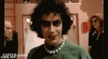 Man With Curly Hair And Pearl Necklace In Green Shirt GIF