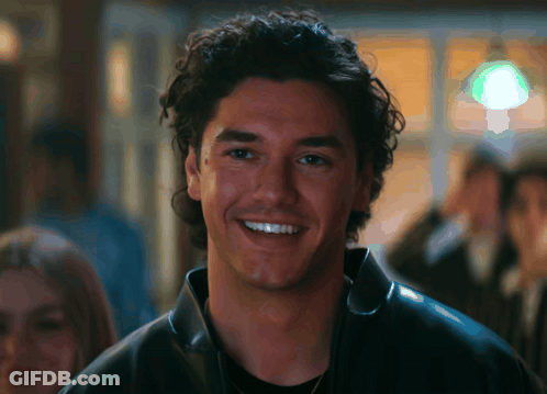 Man With Curly Hair In Black Leather Jacket Smiling GIF