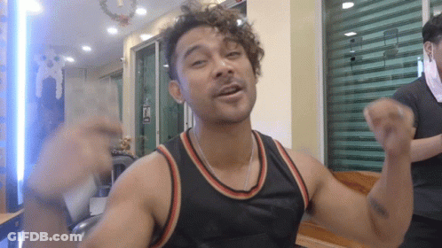 Man With Curly Hair In Black Tank Top With Red And Orange Stripe GIF