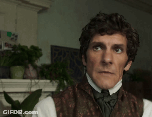 Man With Curly Hair In Brown Vest And Bow Tie GIF
