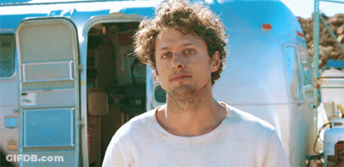 Man With Curly Hair In Front Of Airstream GIF