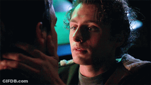 Man With Curly Hair Looking At Another Man GIF
