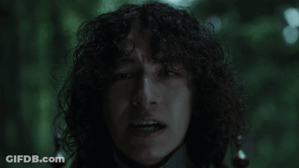 Man With Curly Hair Making Funny Face In Dark GIF