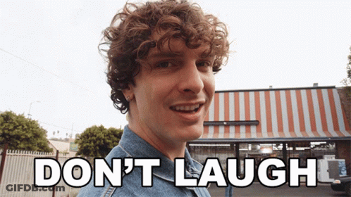 Man With Curly Hair Says Don't Laugh In Front Of Striped Awning GIF