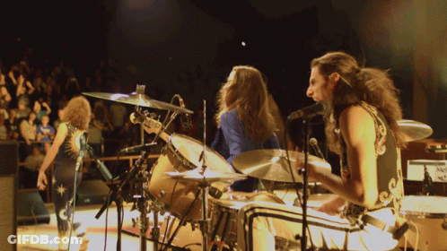 Man With Curly Hair Singing In Blue And Gold Outfit GIF