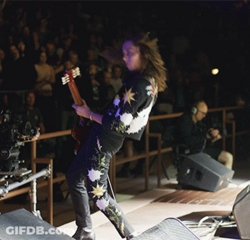 Man With Curly Hair Singing Into Microphone GIF