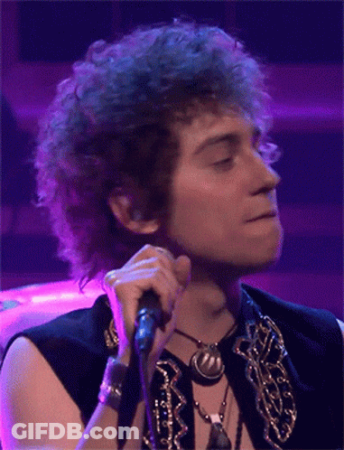 Man With Curly Hair Singing Into Microphone Purple Background GIF