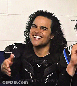 Man With Curly Hair Smiling In Black Shirt GIF