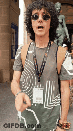 Man With Curly Hair Sunglasses And 'A Few Words' Lanyard GIF
