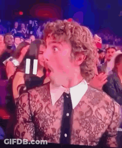 Man With Curly Hair Surprised In Crowd GIF