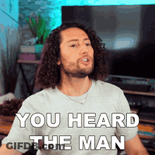 Man With Curly Hair Wearing You Heard The Man T-Shirt GIF