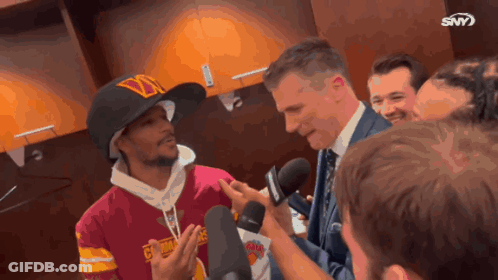 Man With D Hat Interviewed By Suited Man GIF