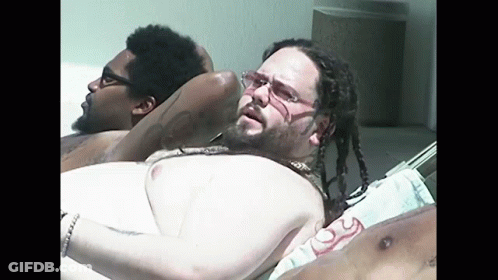 Man With Dreadlocks And Glasses Laying On Beach GIF