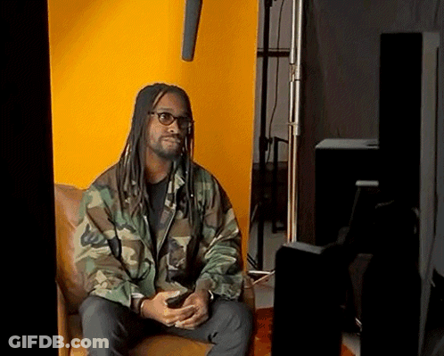 Man With Dreadlocks And Glasses Sitting In Chair GIF