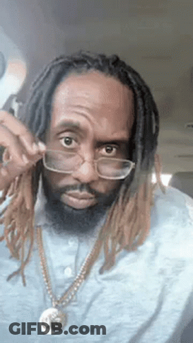 Man With Dreadlocks And Glasses Wearing Necklace And Blue Shirt GIF