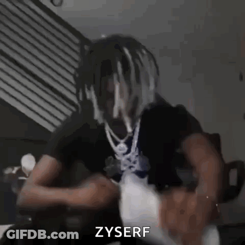 Man With Dreadlocks And Necklace On Couch GIF