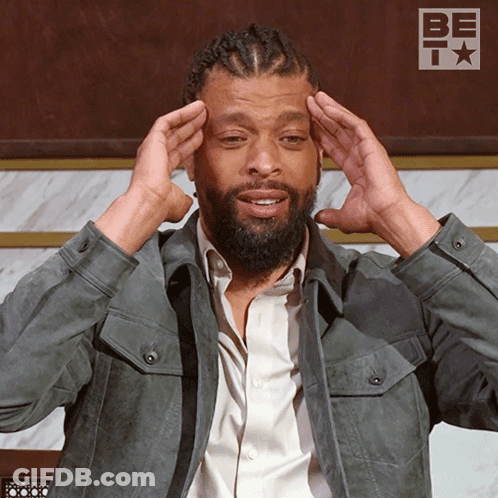 Man With Dreadlocks Holding Head In Front Of Be It Sign GIF