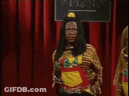 Man With Dreadlocks Holding Microphone In Front Of Red Curtain GIF