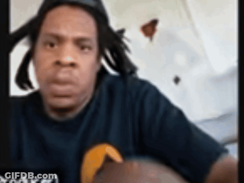 Man With Dreadlocks In Black Shirt With Yellow Circle GIF
