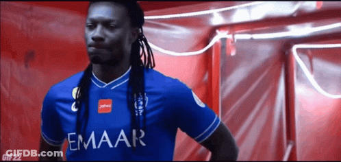 Man With Dreadlocks In Blue Emaar Shirt GIF