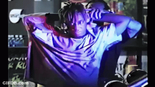 Man With Dreadlocks In Dark Room With Purple Light GIF