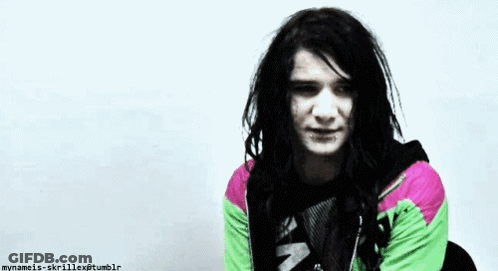 Man With Dreadlocks In Green And Pink Jacket GIF