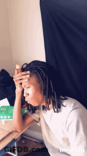 Man With Dreadlocks Sitting At Desk Hand On Head GIF