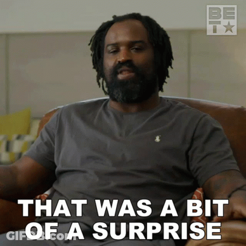 Man With Dreadlocks Sitting On Couch Saying That Was A Bit Of A Surprise GIF