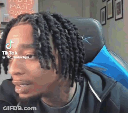 Man With Dreadlocks Sitting With TikTok Sticker On Forehead GIF