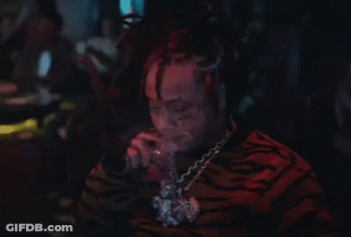 Man With Dreadlocks Smoking Cigarette In Dark Room GIF