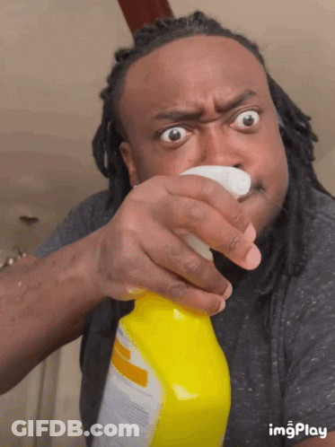 Man With Dreadlocks Spraying Yellow Bottle Of Cleaner GIF