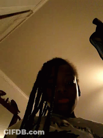 Man With Dreadlocks Standing In Dark Room GIF