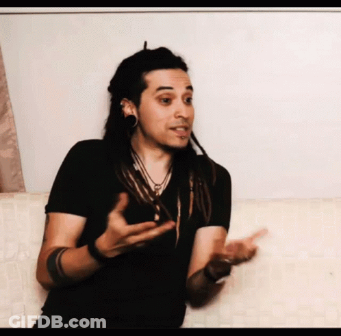 Man With Dreadlocks Talking On Couch GIF