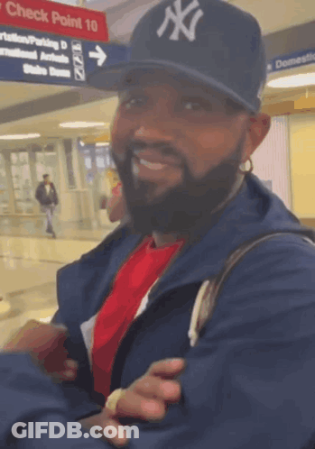 Man With Earbuds Smiling Beside Blue Stuffed Animal GIF