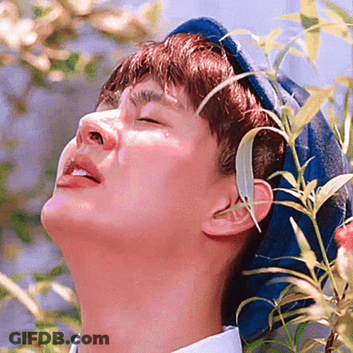 Man With Eyes Closed And Plant In Ear GIF