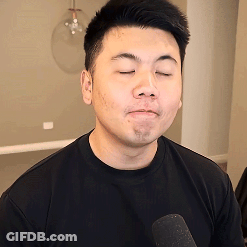 Man With Eyes Closed In Black Shirt And Microphone GIF