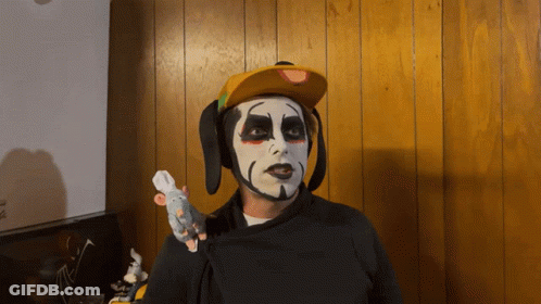 Man With Face Paint And Yellow Hat Holding Stuffed Mouse GIF
