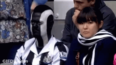 Man With Face Paint Sitting Next To Woman In Scarf GIF