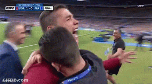 Man With France Lanyard Hugging Another GIF