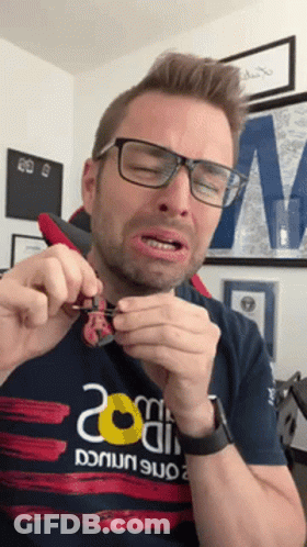 Man With Glasses And 20 Shirt Holding Something GIF