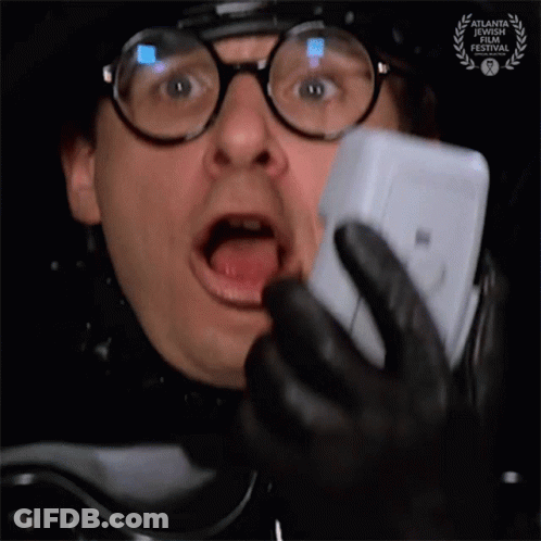 Man With Glasses And Badge Talking On Phone GIF