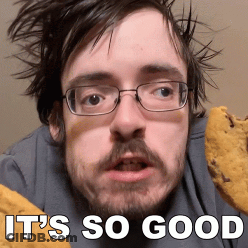 Man With Glasses And Beard Holding Cookie Saying It's So Good GIF