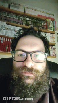 Man With Glasses And Beard In Front Of Bookshelf GIF