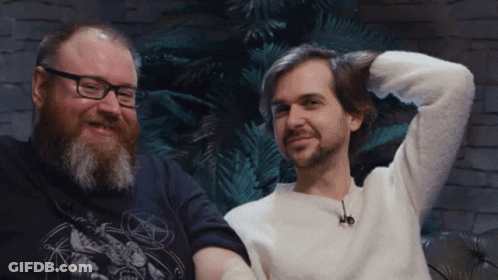Man With Glasses And Beard Next To Man With Pentagram Shirt GIF