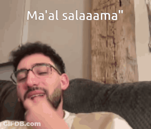 Man With Glasses And Beard Sitting On Couch Ma 'Al Salaama GIF