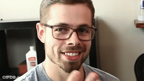Man With Glasses And Beard Smiling Near Cleaner Bottle GIF
